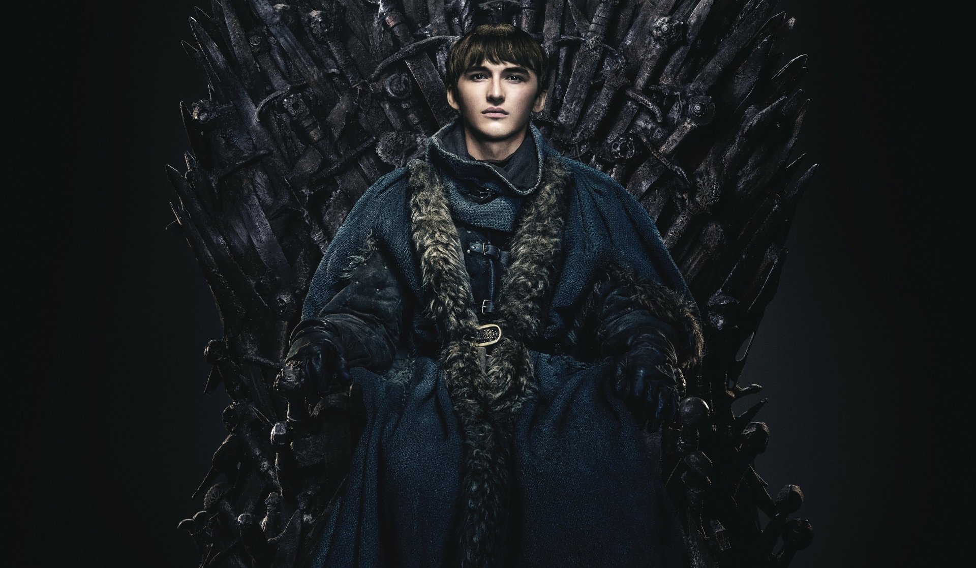 Bran Stark from Game of Thrones seated on the Iron Throne in a dark fur-lined cloak; 2K Quad HD PC desktop wallpaper/background.