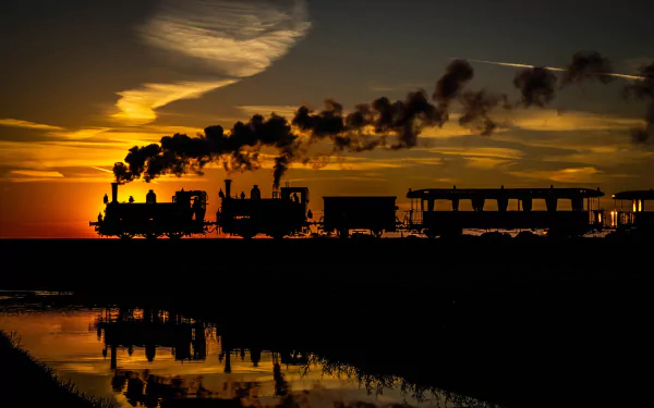 Silhouette of a train and its reflection on water during sunset, with smoke trailing behind. HD desktop wallpaper and background.