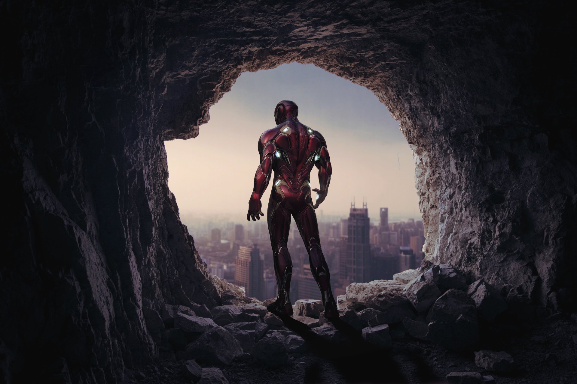 Iron Man stands at the entrance of a cave overlooking a cityscape, depicted in a 4K Ultra HD wallpaper inspired by the Avengers EndGame movie.
