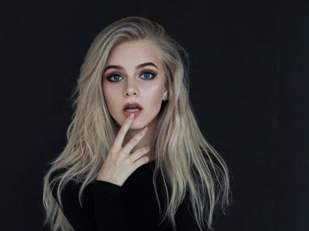 HD desktop wallpaper featuring a blonde woman model with long hair and striking blue eyes against a dark background.