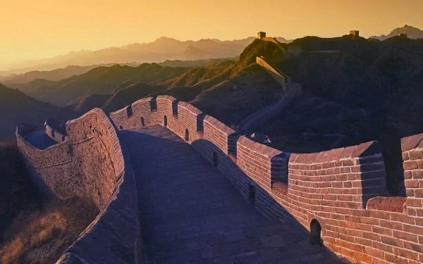 A breathtaking view of the Great Wall of China, showcasing its impressive stone structure winding over mountains at sunset. This HD image makes for a striking desktop background.