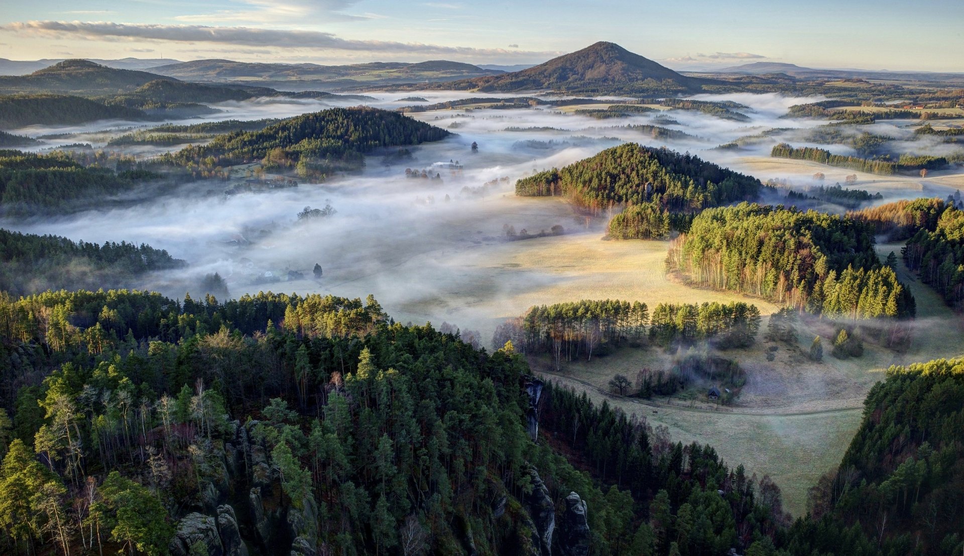 Mist-filled valleys weave through dense forests and rolling hills in a serene Czech Republic landscape, captured in this HD desktop wallpaper.