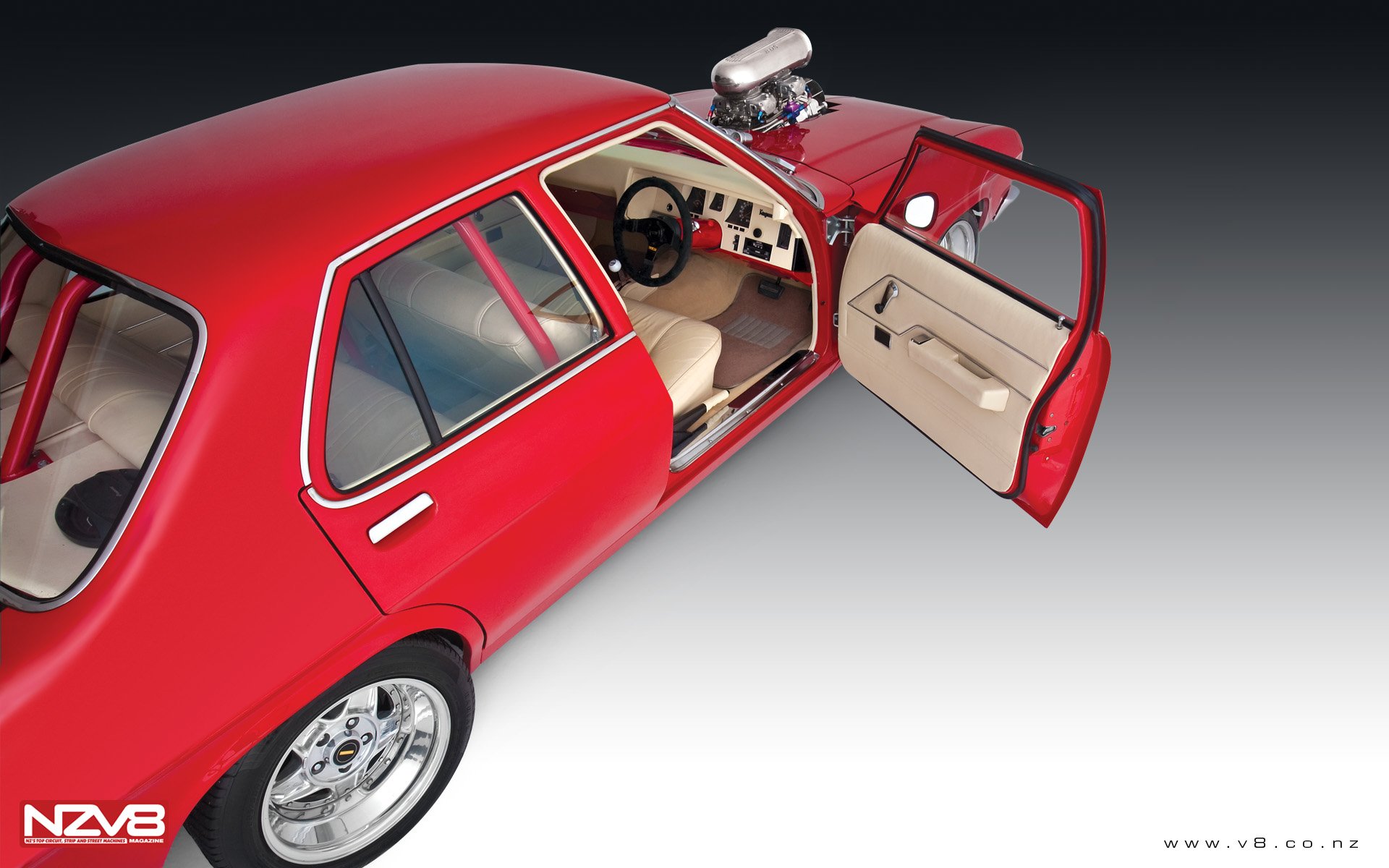 HD desktop wallpaper featuring a vibrant red Holden vehicle with an open door, showcasing a detailed interior and polished exterior against a gradient background.