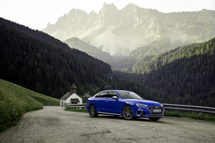 Blue Audi S4 compact car parked on a mountain road amid forested valleys and jagged peaks — 4K Ultra HD PC desktop wallpaper background.