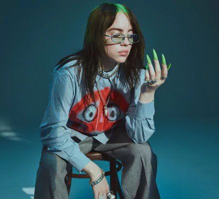 American singer Billie Eilish wearing glasses and a striped shirt with a red graphic, captured in a 4K Ultra HD PC desktop wallpaper and background.