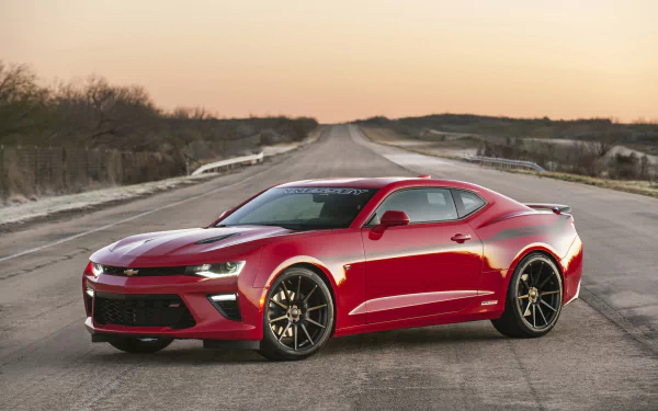 Red Hennessey Chevrolet Camaro SS HPE 600 muscle car parked on an open road at sunset, shown in 4K Ultra HD desktop wallpaper quality.