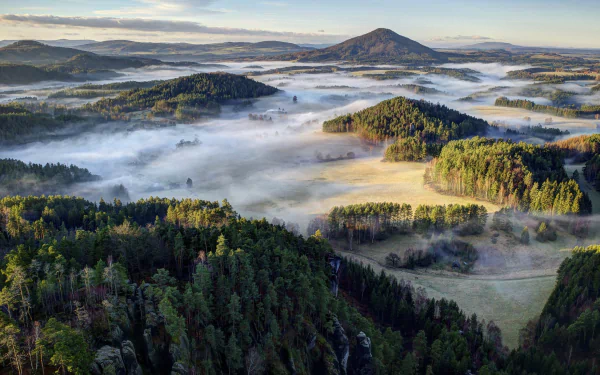 Mist-filled valleys weave through dense forests and rolling hills in a serene Czech Republic landscape, captured in this HD desktop wallpaper.