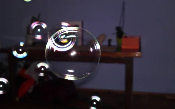 A close-up photograph of a floating bubble with colorful reflections, set against a blurred indoor background, presented as a 4K Ultra HD PC desktop wallpaper.