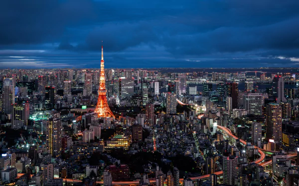 Nighttime cityscape of Tokyo featuring illuminated Tokyo Tower surrounded by skyscrapers and buildings in this HD PC desktop wallpaper from Japan.