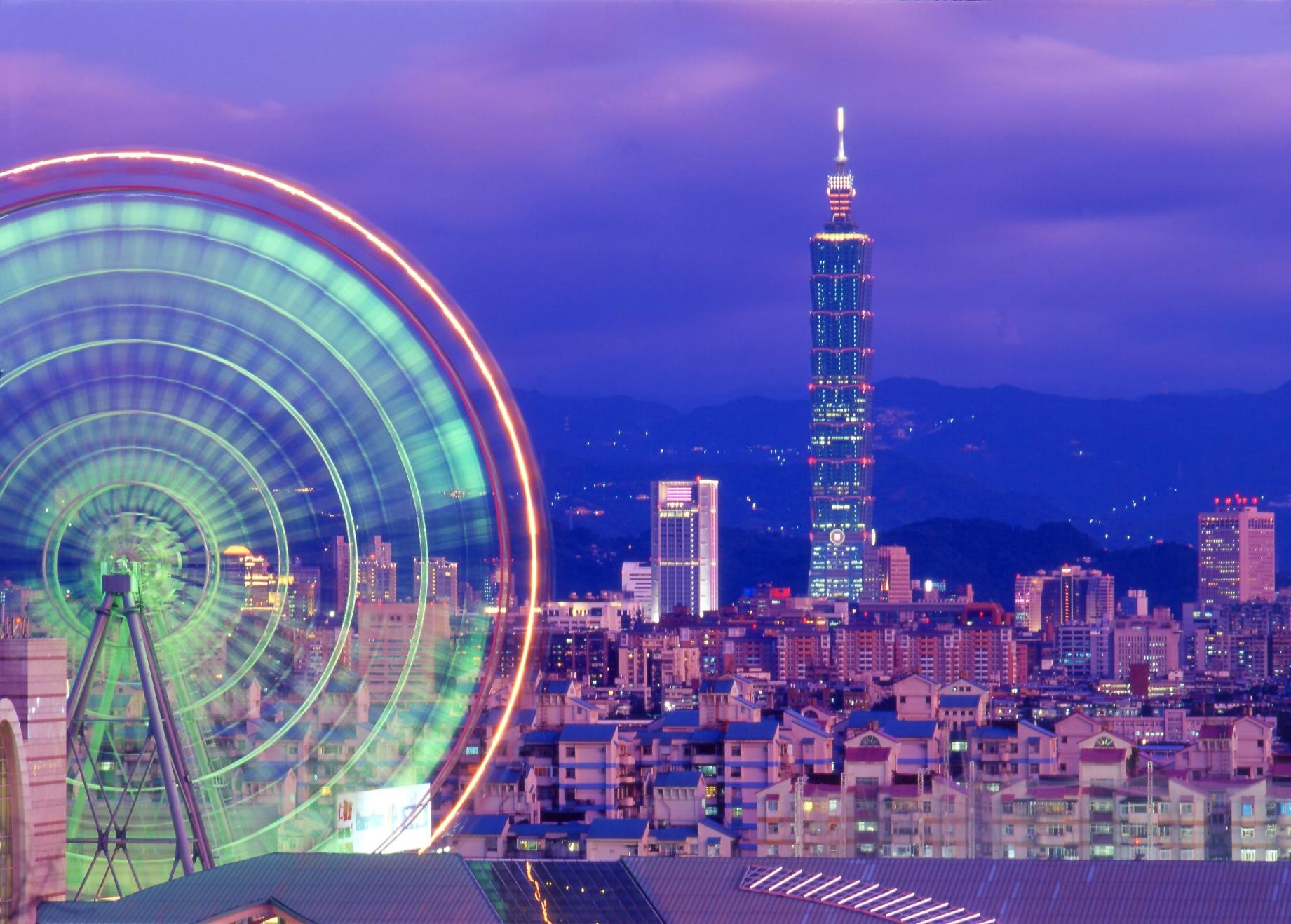 HD desktop wallpaper featuring a vibrant night view of Taipei cityscape with the illuminated Taipei 101 tower and a glowing Ferris wheel against a twilight sky.