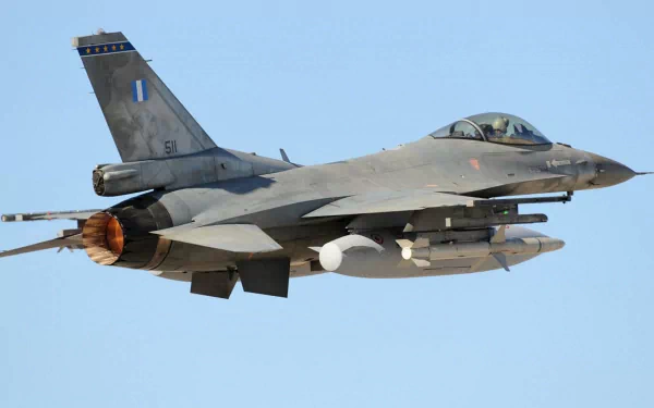 A General Dynamics F-16 Fighting Falcon military jet in flight, showcasing its sleek design and powerful engines. This high-definition image serves as a striking PC desktop wallpaper.