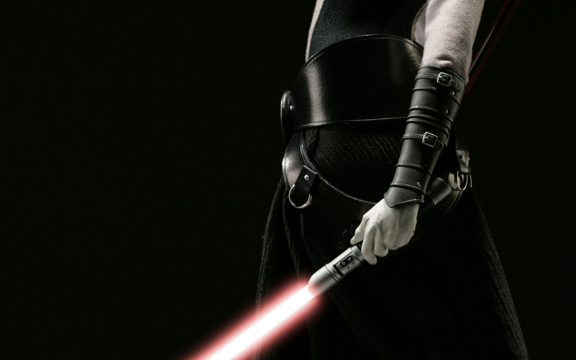 A striking HD desktop wallpaper featuring a dark-clad figure wielding a red lightsaber, evocative of the Star Wars sci-fi universe.