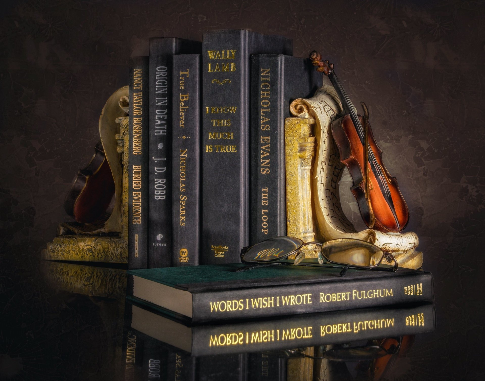Still-life photography of a violin resting against stacked books with ornate bookends — HD PC desktop wallpaper and background.