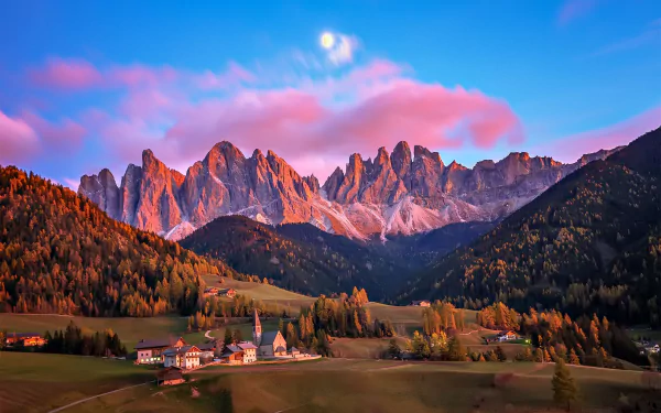 A vibrant HD wallpaper showcasing a charming man-made village set against the stunning Dolomites mountain range in Italy under a colorful sky.