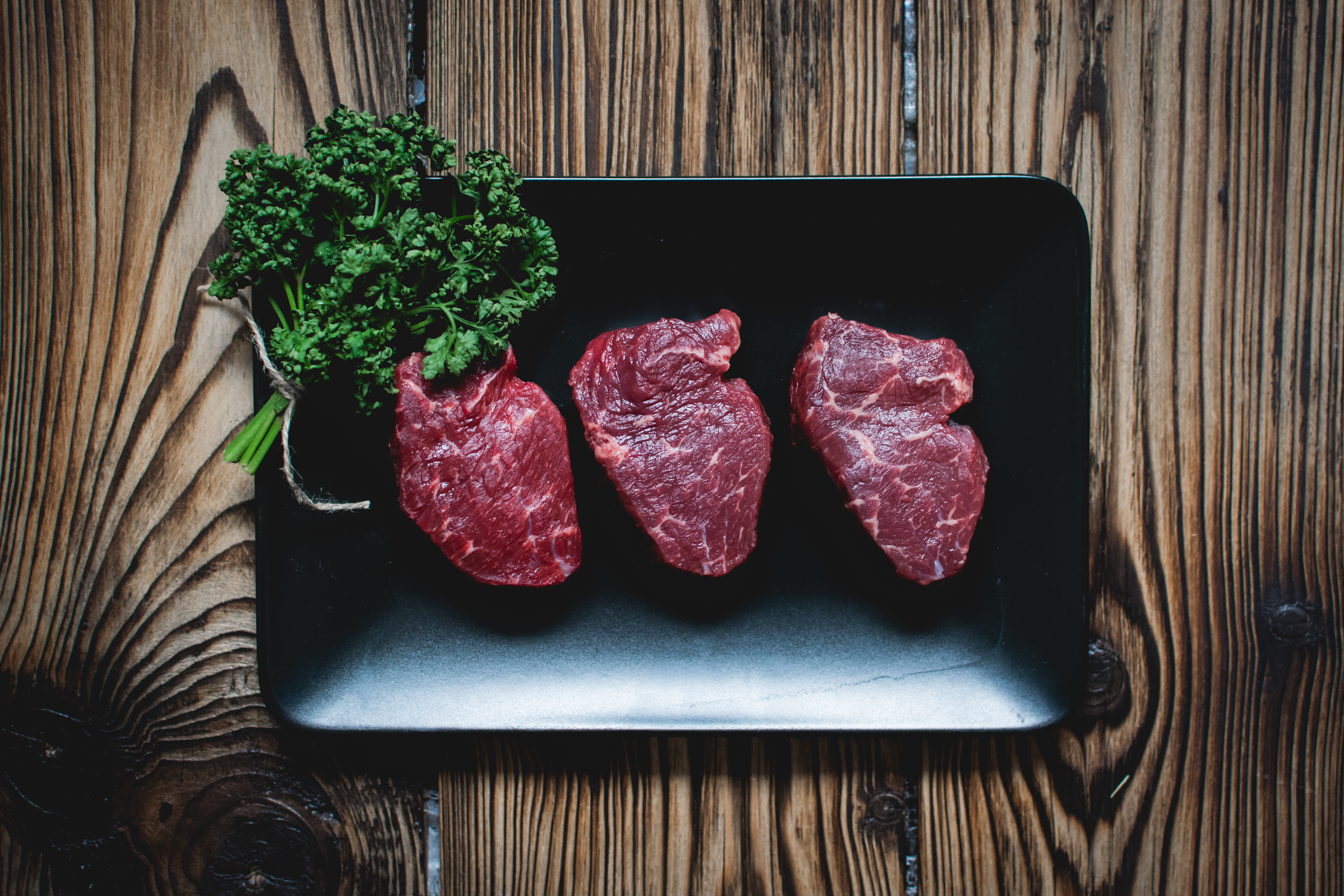 Raw beef steaks by Jakub Kapusnak