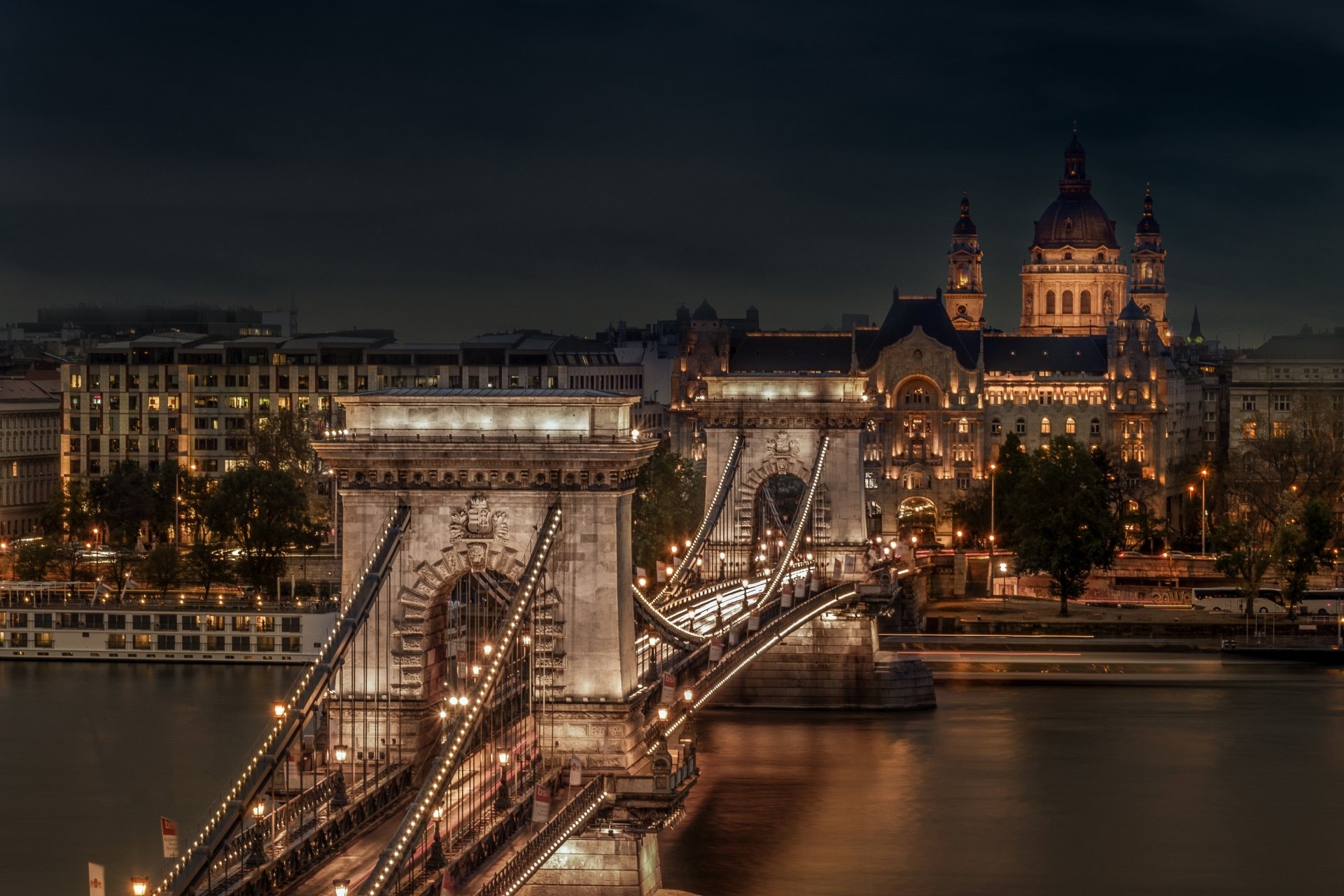 Night view of the illuminated Chain Bridge spanning the Danube River in Budapest, Hungary, showcasing the city's historic architecture in 4K Ultra HD clarity.