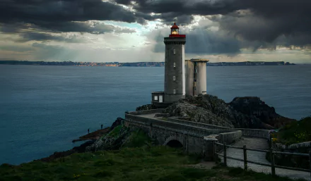Dramatic view of a man-made lighthouse on the rocky coast of Brittany, France, overlooking the sea under a moody sky in 4K Ultra HD detail.