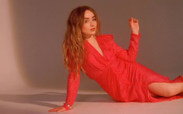 HD music-themed PC desktop wallpaper showing a female singer in a red dress reclining against a neutral backdrop.