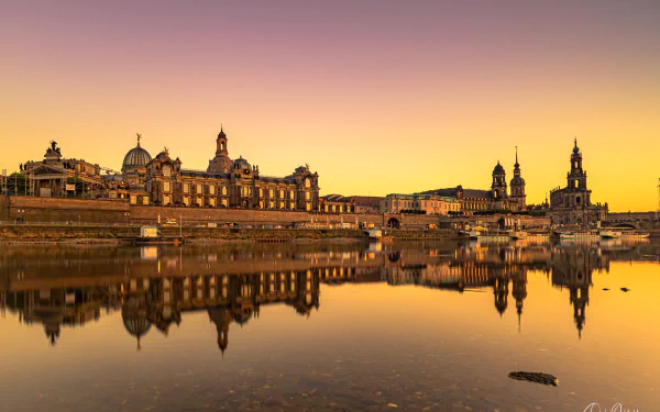 HD desktop wallpaper showcasing the man-made skyline of Dresden reflected in calm waters during a golden sunset.