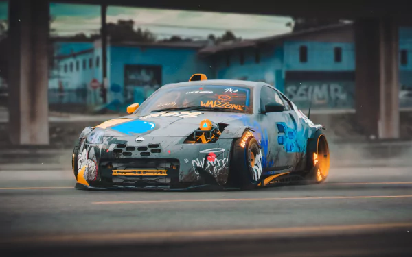 8K Ultra HD PC desktop wallpaper/background of a modified vehicle — a graffiti-covered Nissan 370Z with wide body, glowing orange rims and motion blur on an urban street.