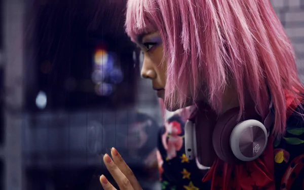 Profile of a short pink-haired woman wearing headphones, her face reflected in glass — vivid 8K Ultra HD PC desktop wallpaper featuring a stylized model portrait.