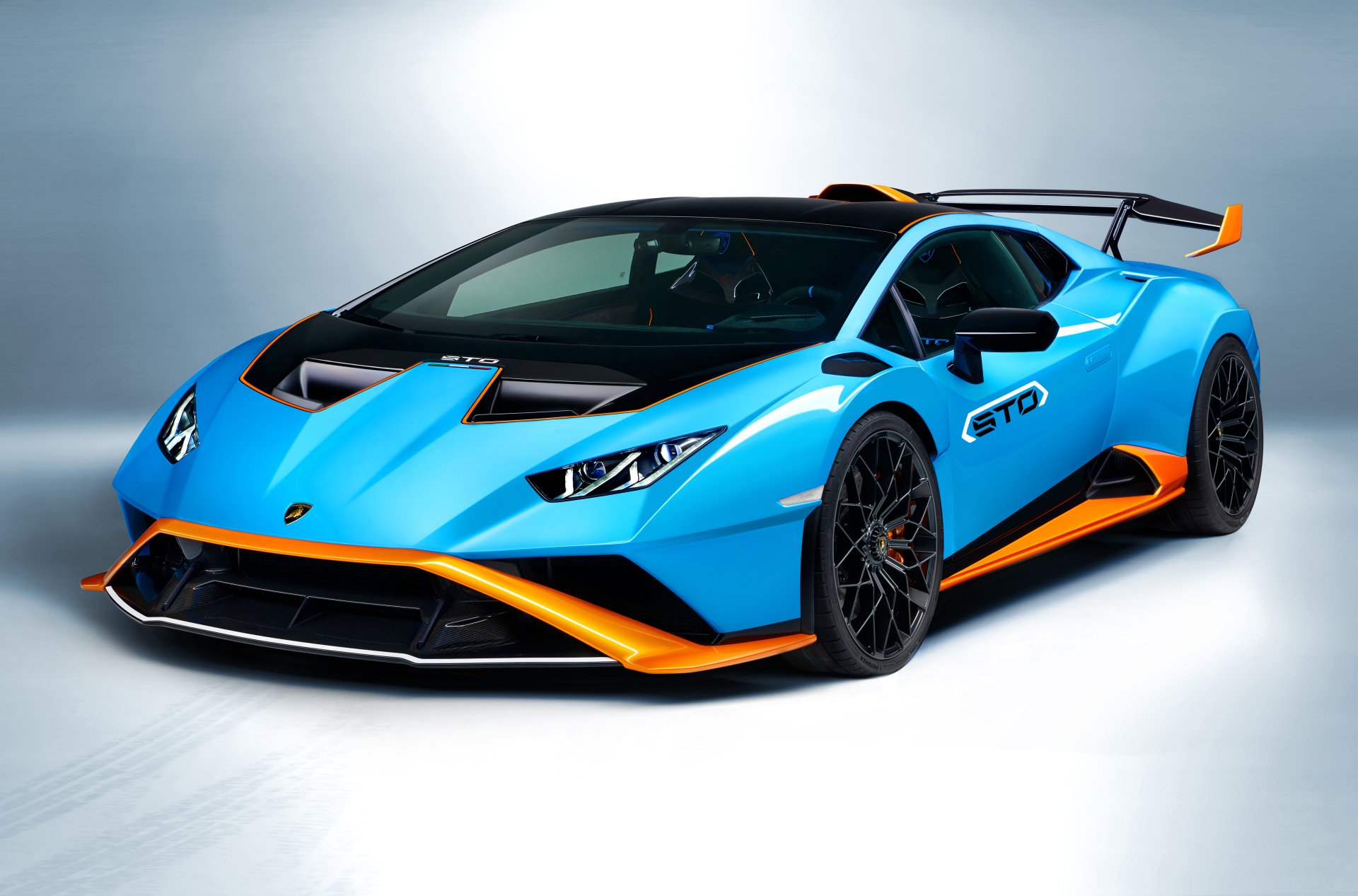 A blue Lamborghini Huracán STO supercar with orange accents displayed as a 4K Ultra HD PC desktop wallpaper and background.