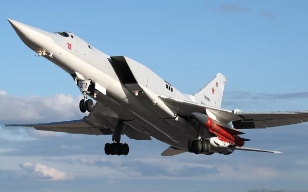HD desktop wallpaper showing a Tupolev Tu-22 military bomber aircraft in flight against a clear sky background.
