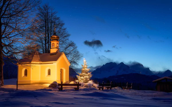 A snowy winter night in Germany with a warmly lit chapel beside a glowing Christmas tree under a clear starry sky, capturing a peaceful religious holiday scene.