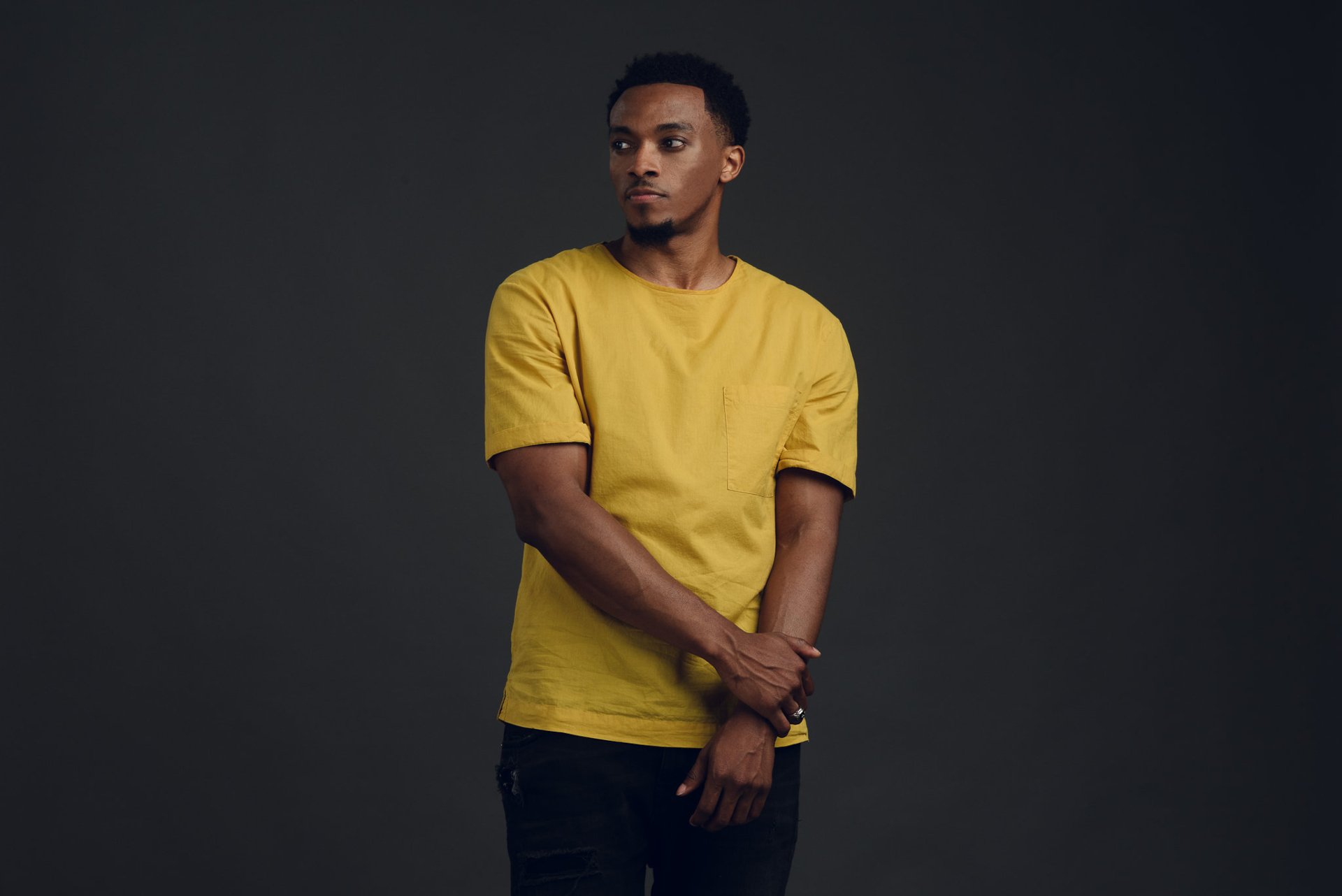 Man in yellow shirt posing for a HD desktop wallpaper and background.