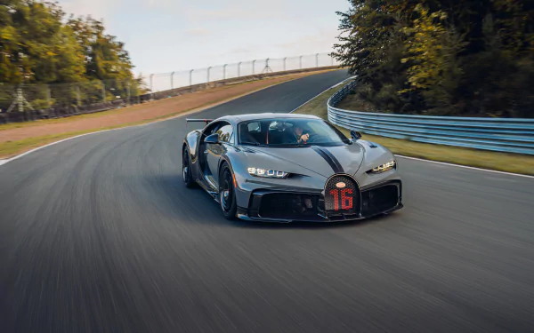 A sleek Bugatti Chiron Pur Sport supercar speeds along a curving race track, captured in stunning 8K Ultra HD as a dynamic PC desktop wallpaper.