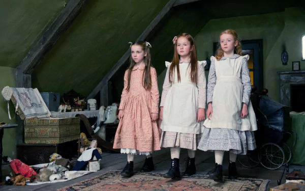 Three girls in Victorian dresses stand in a dim attic among scattered toys, eerie scene from the movie The Woman In Black — HD PC desktop wallpaper and background.