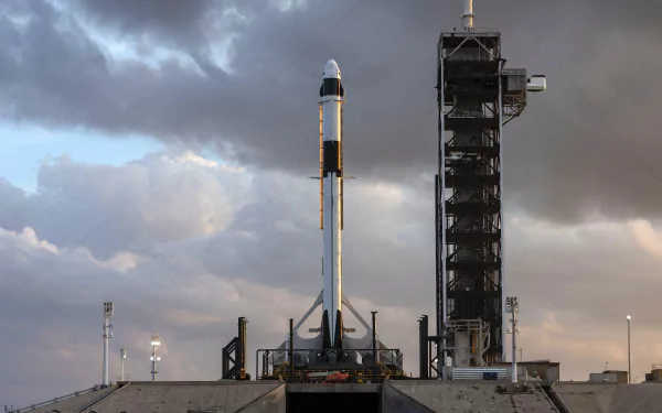 HD desktop wallpaper of SpaceX Falcon 9 rocket poised for launch at the launchpad with a cloudy sky backdrop.