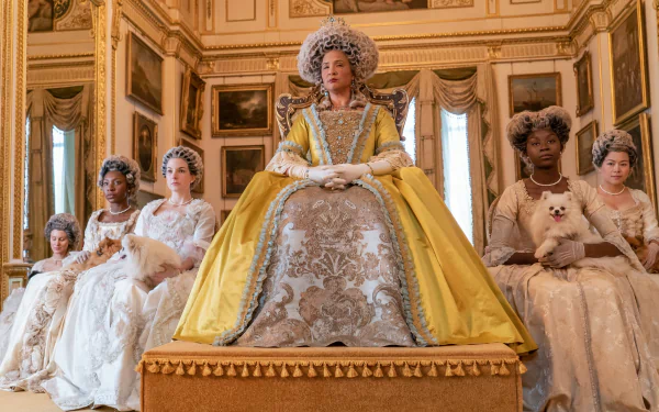 HD desktop wallpaper of Bridgerton featuring characters in regal attire sitting in an opulent room.