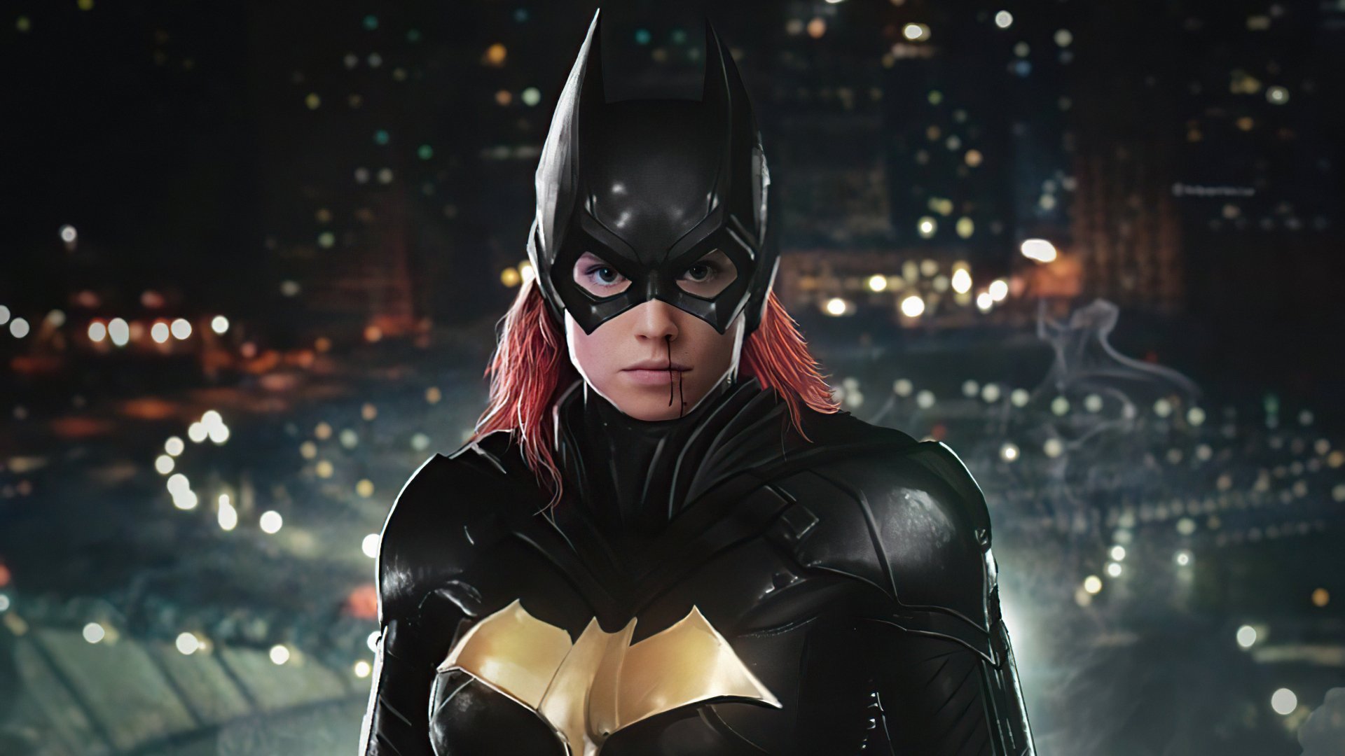 DC Comics Batgirl in an armored black-and-gold suit with red hair under the cowl, facing forward against a lit city skyline at night — 4K Ultra HD PC desktop wallpaper
