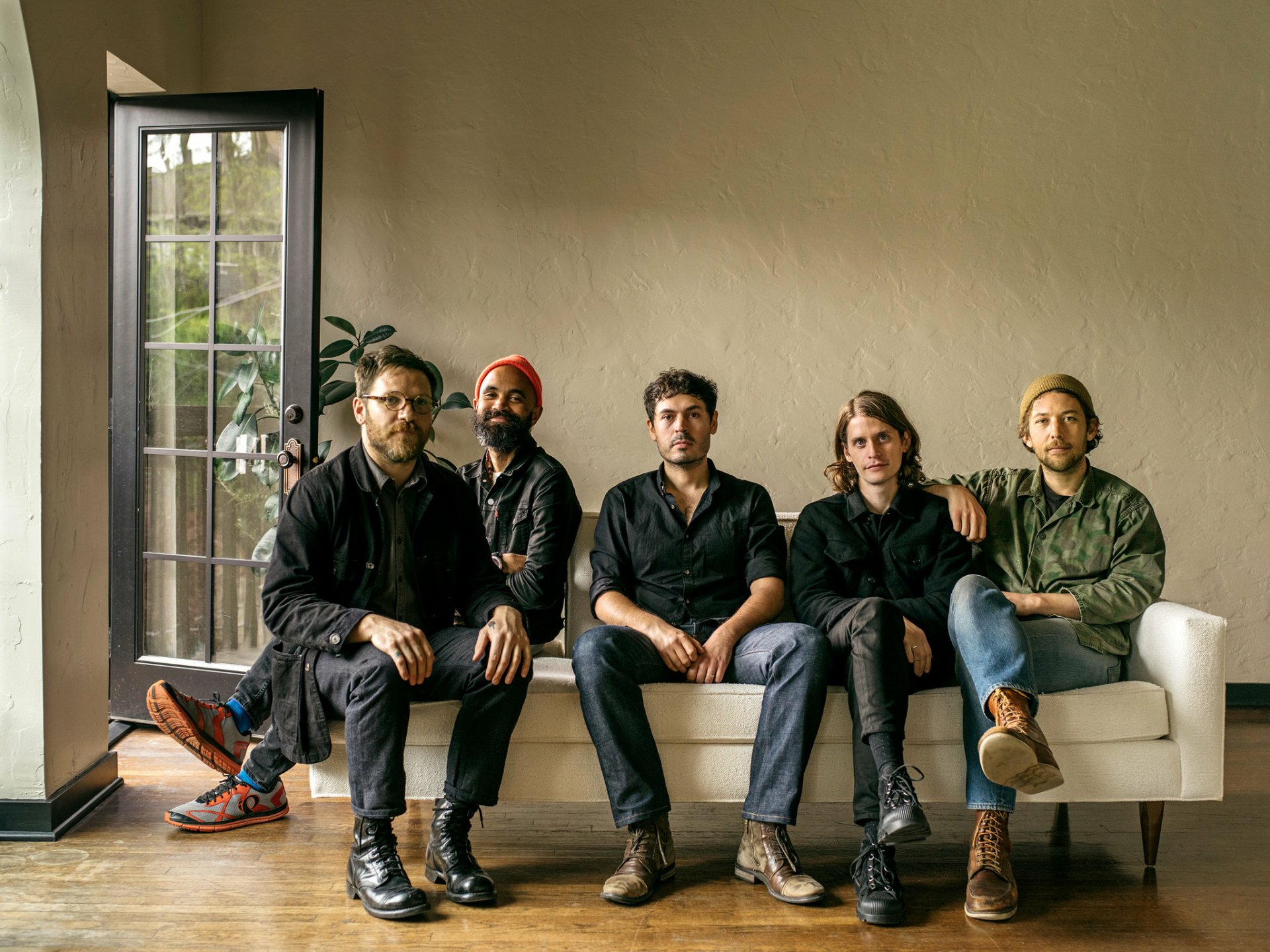 Fleet Foxes band members seated casually in a room, serving as HD desktop wallpaper and background.