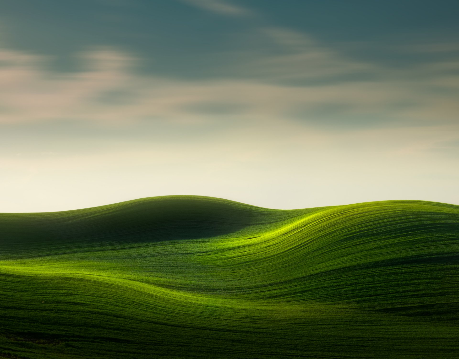 4K Ultra HD PC desktop wallpaper and background of rolling green hills — lush greenery and a tranquil natural landscape beneath a soft, pastel sky.