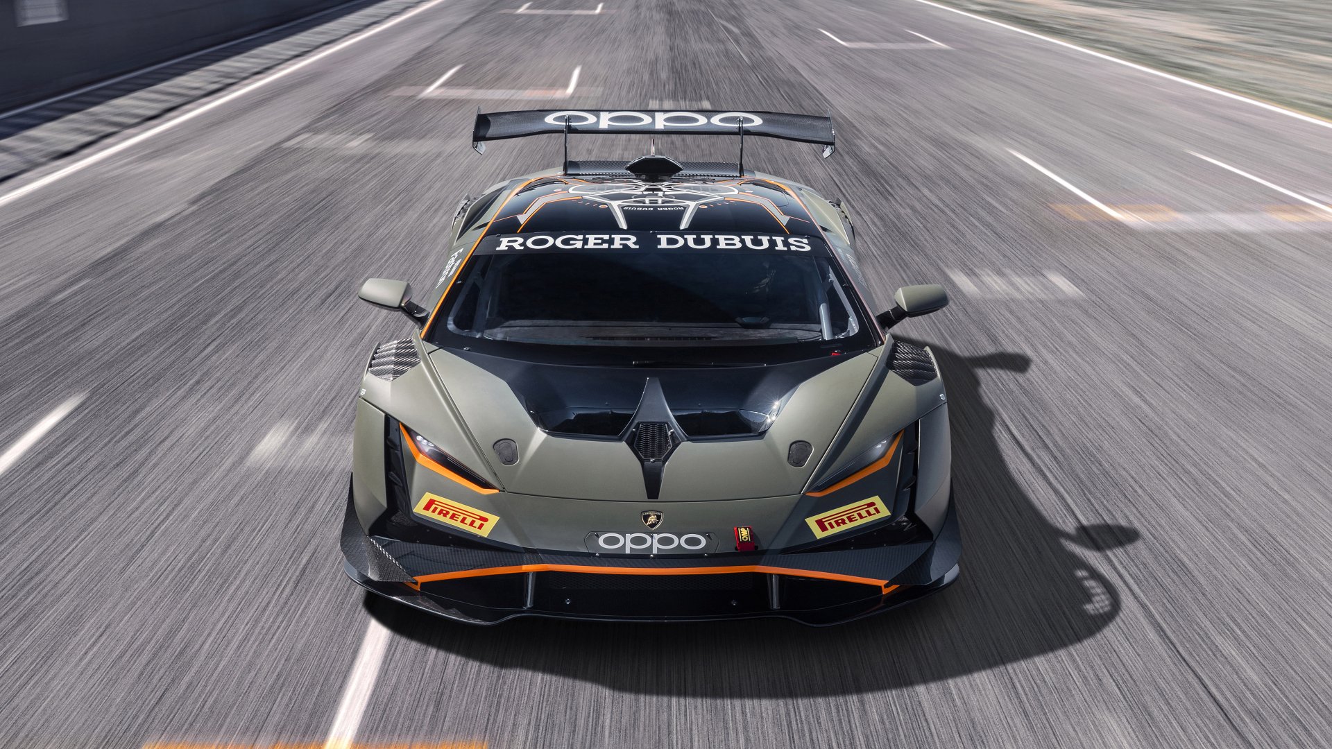 Front view of matte gray Lamborghini Huracan supercar with sponsor decals, charging down a racetrack — 4K Ultra HD PC desktop wallpaper.