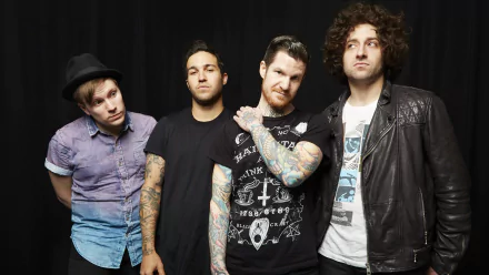 Four band members posing for an HD desktop wallpaper, all dressed in casual attire with contrasting styles, from a band associated with the tag Fall Out Boy.