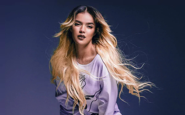 HD desktop wallpaper featuring a person with blonde hair in motion against a purple backdrop, embodying a vibrant, edgy look.