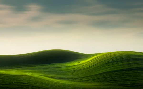 4K Ultra HD PC desktop wallpaper and background of rolling green hills — lush greenery and a tranquil natural landscape beneath a soft, pastel sky.