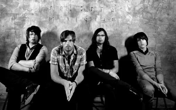 HD desktop wallpaper featuring the members of the band Kings Of Leon against a textured backdrop in monochrome.