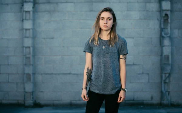 HD desktop wallpaper of a person standing in front of a grey wall, tagged with Julien Baker.