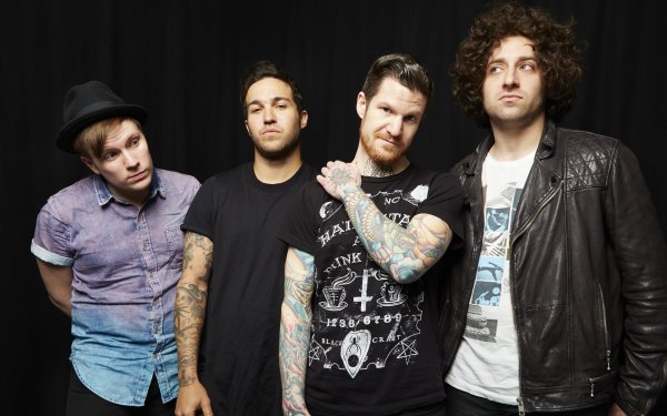 Four band members posing for an HD desktop wallpaper, all dressed in casual attire with contrasting styles, from a band associated with the tag Fall Out Boy.