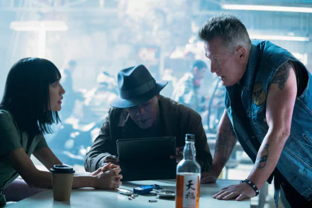 HD desktop wallpaper featuring Robert Patrick, Samuel L. Jackson, and Maggie Q in a scene from the movie The Protégé, gathered around a table with intense expressions.