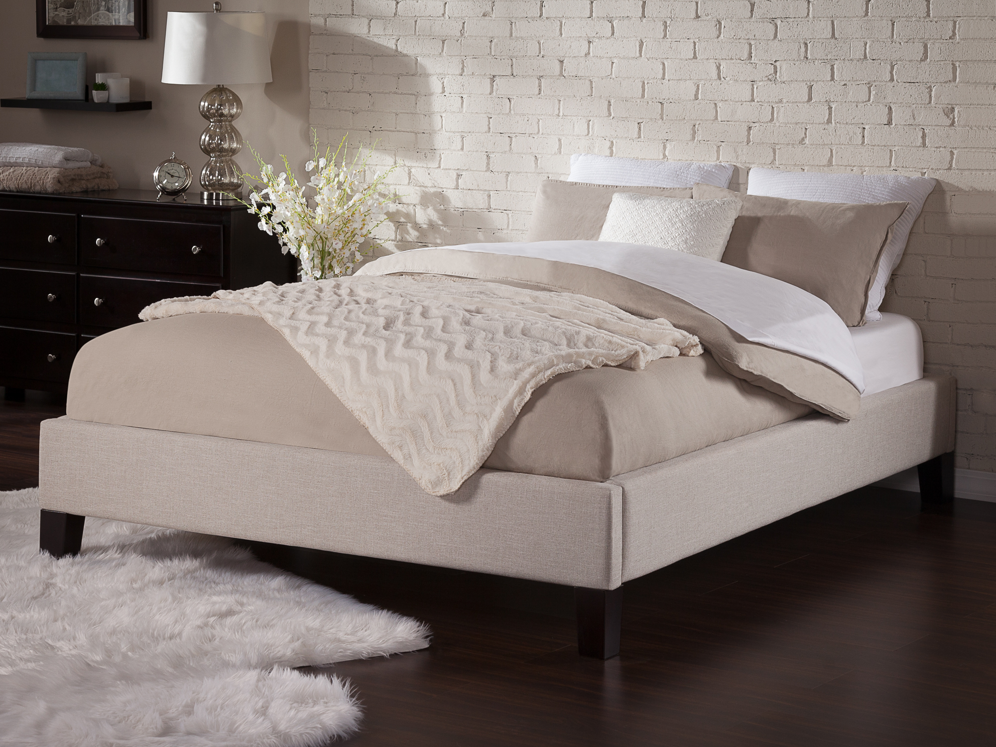 Cozy modern bed with pillows and a beige comforter in a stylish bedroom setup, ideal for HD desktop wallpaper and background.