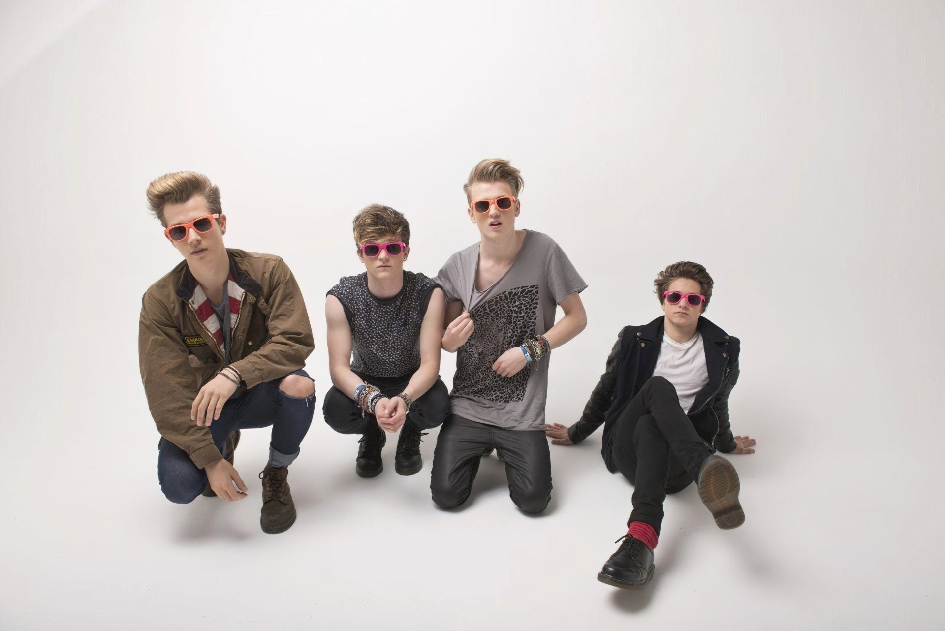 HD desktop wallpaper featuring The Vamps, a four-member band, posing stylishly in colorful sunglasses against a minimalist white background.