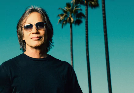 HD desktop wallpaper featuring a person with sunglasses and palm trees in the background.