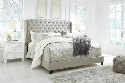 Chic bedroom featuring a plush upholstered bed, serene color palette, and elegant furnishings, set in a bright space with large windows, creating a soothing atmosphere for an HD desktop wallpaper.