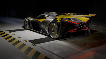 4K Ultra HD PC desktop wallpaper: rear three-quarter view of a yellow-and-black Bugatti Bolide supercar in a dim industrial garage, glossy aerodynamic body and prominent rear wing.