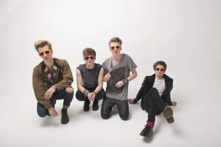 HD desktop wallpaper featuring The Vamps, a four-member band, posing stylishly in colorful sunglasses against a minimalist white background.